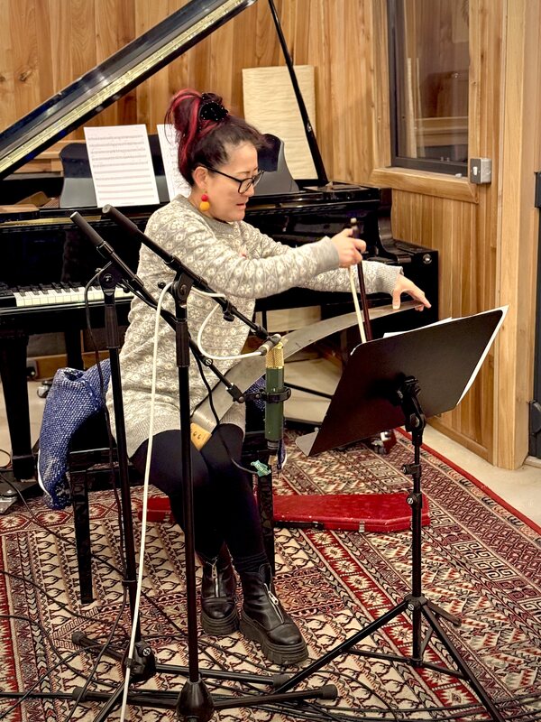 A guest musician bowing a singing saw